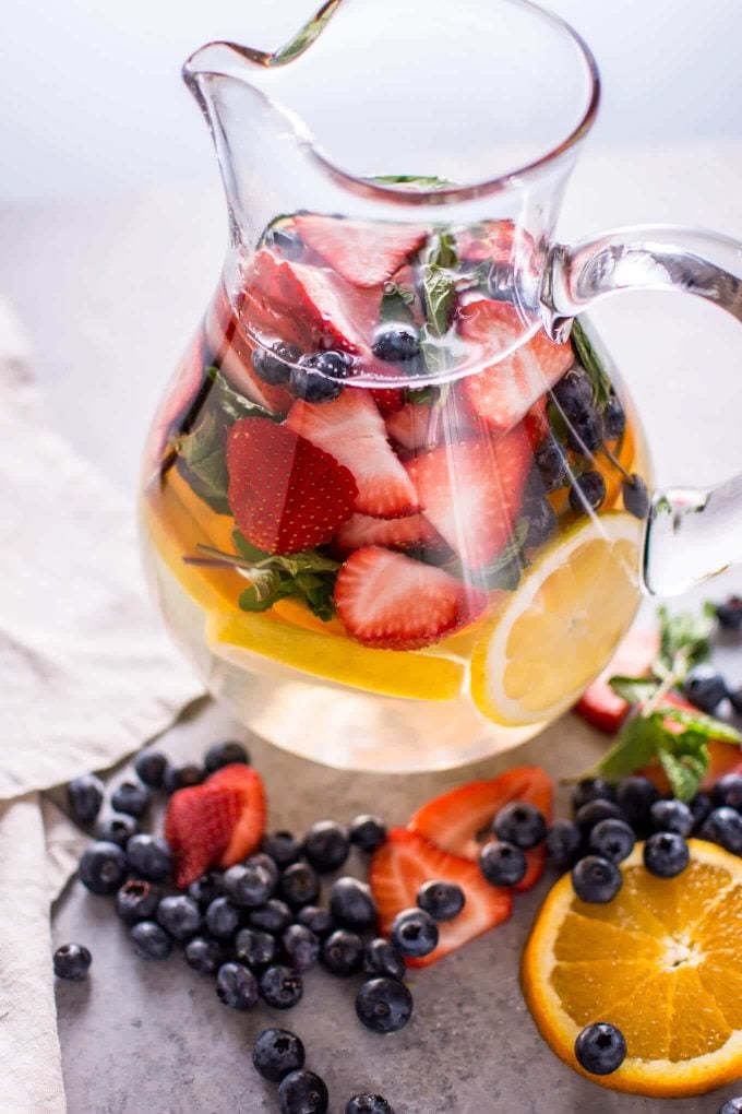 glass pitcher of rainbow fruit infused water