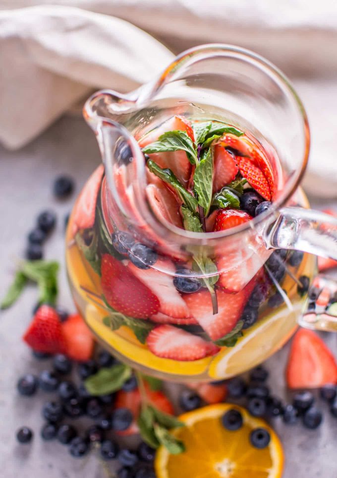 close-up of mint water infused with fruit in a glass pitcher