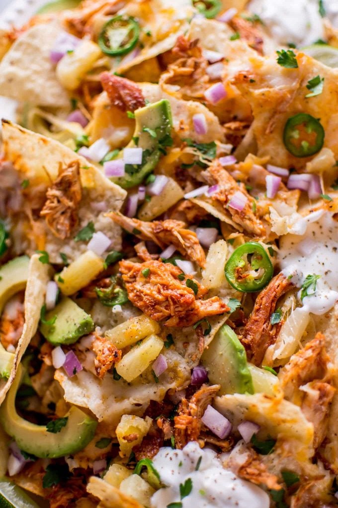 close-up of tropical chicken nachos with pineapple and jalapeno slices