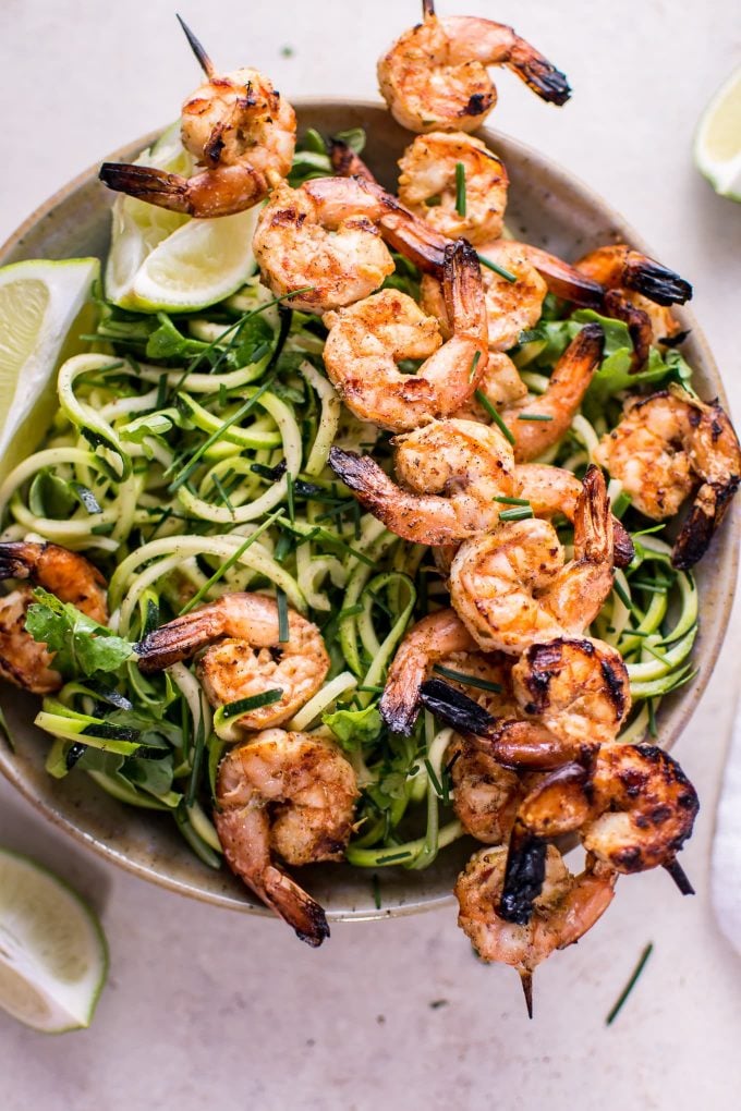 bowl with grilled chili lime shrimp zoodles and lime wedges