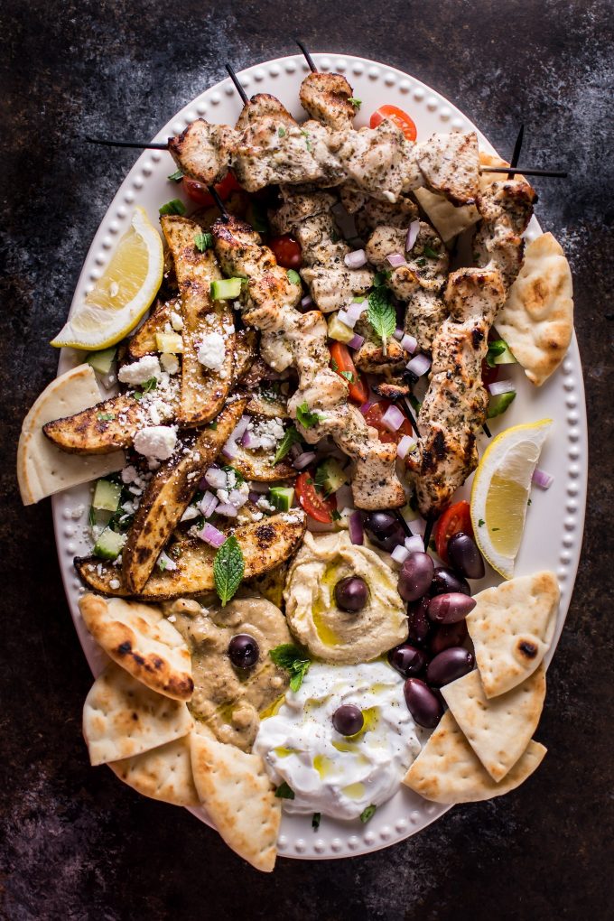 ultimate Greek chicken souvlaki on an oval serving platter with lemon and pita bread