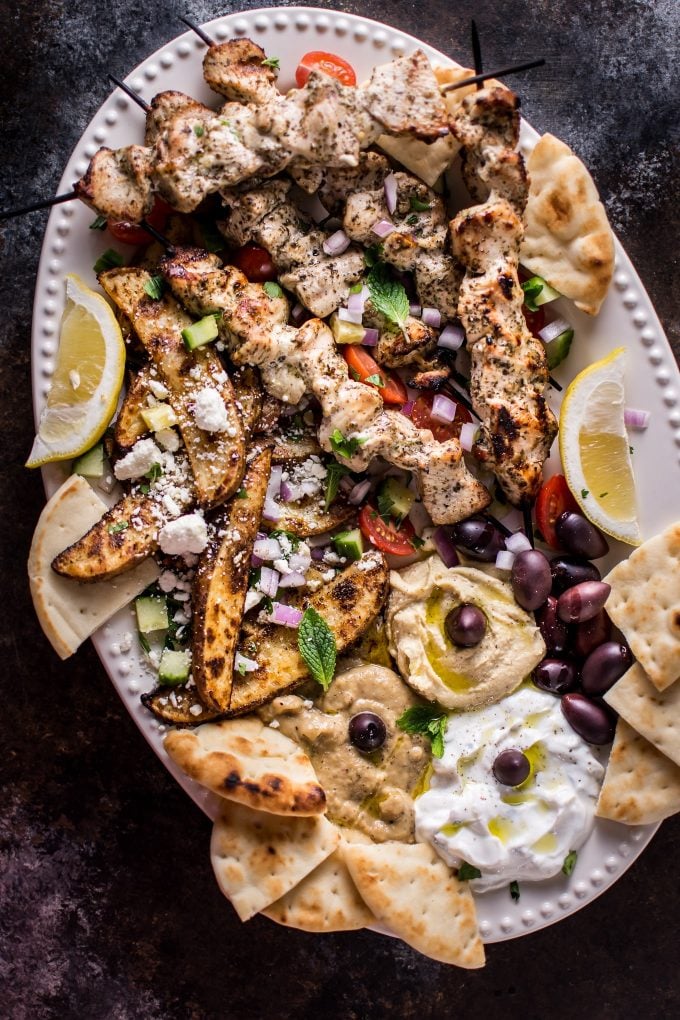 platter with Greek chicken souvlaki, hummus, tzatziki, olives, feta, and pita bread