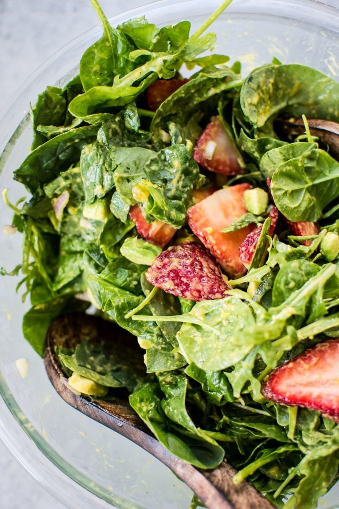 close-up of strawberry spinach salad with fresh mango dressing