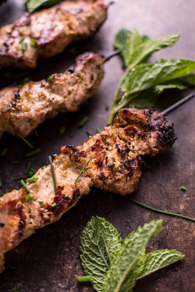 close-up of a grilled Vietnamese lemongrass pork tenderloin skewer with grill marks and mint sprig