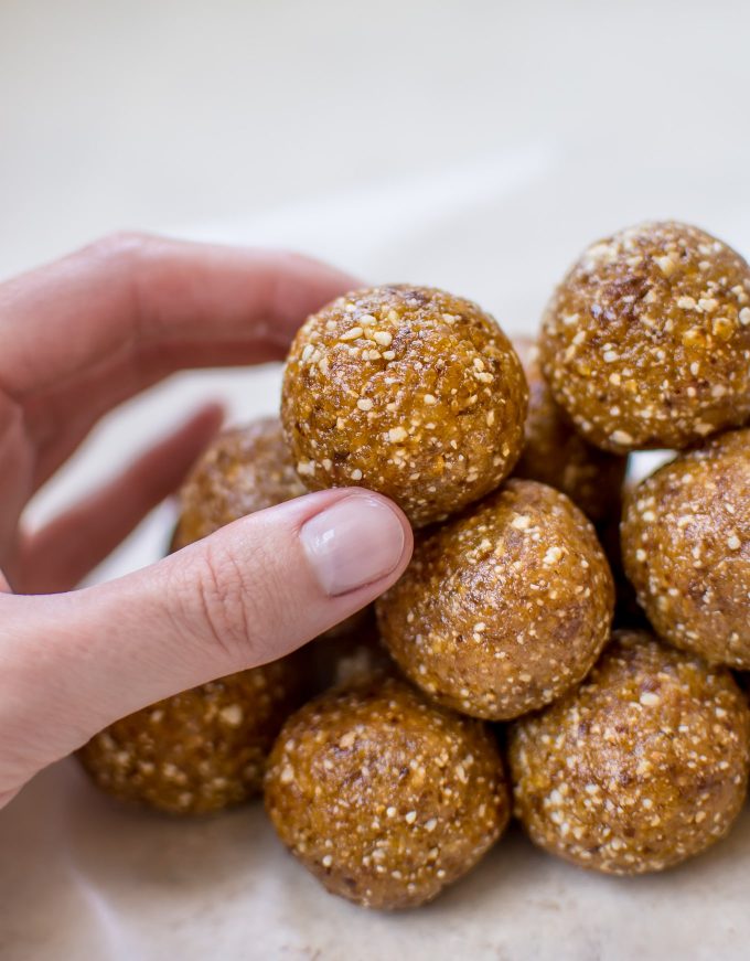 female hand holding three-ingredient apricot bliss ball