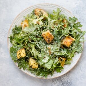 This baby kale salad is an easy and fast way to enjoy kale. The lemon tahini dressing and garlicky parmesan croutons make this a wonderfully flavorful salad!