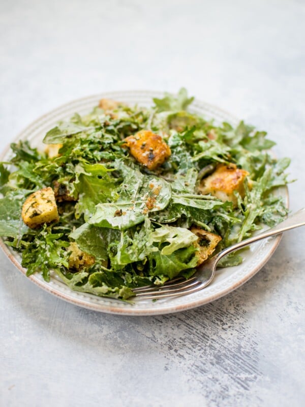 This baby kale salad is an easy and fast way to enjoy kale. The lemon tahini dressing and garlicky parmesan croutons make this a wonderfully flavorful salad!
