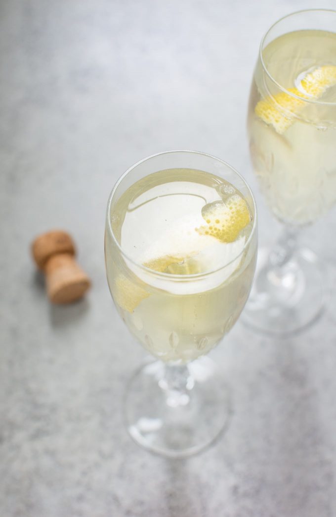 two glasses of lemon champagne cocktail beside a cork