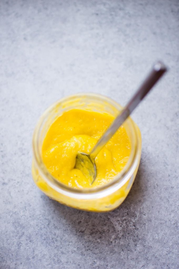 glass jar with mango salad dressing and a spoon