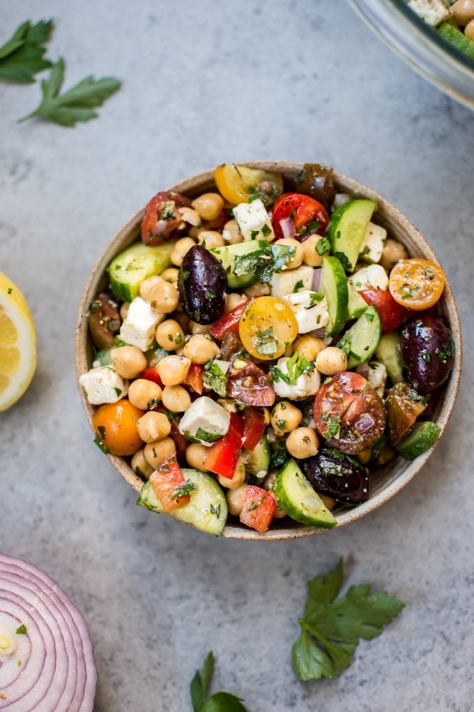 bowl of Mediterranean chickpea salad with tomatoes, cucumber, olives, and feta