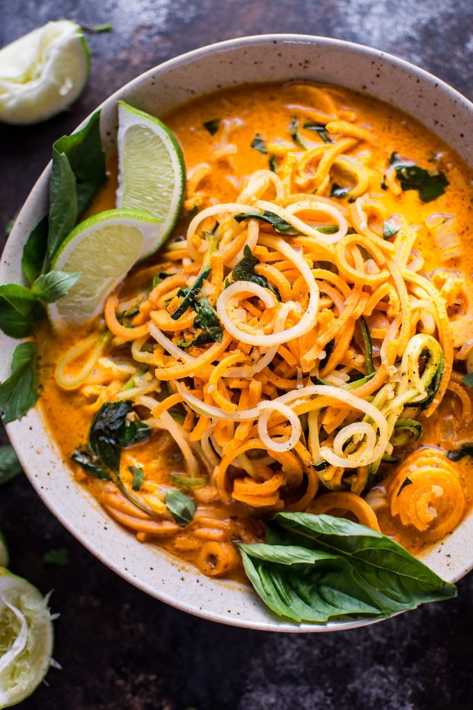 close-up of spiralized Thai coconut curry soup in a bowl with lime wedges