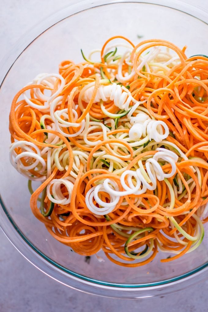 spiralized sweet potato, zucchini, and celery root in a glass bowl