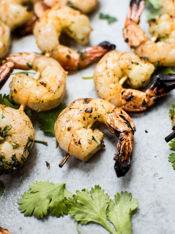grilled tequila lime shrimp skewers next to cilantro leaves