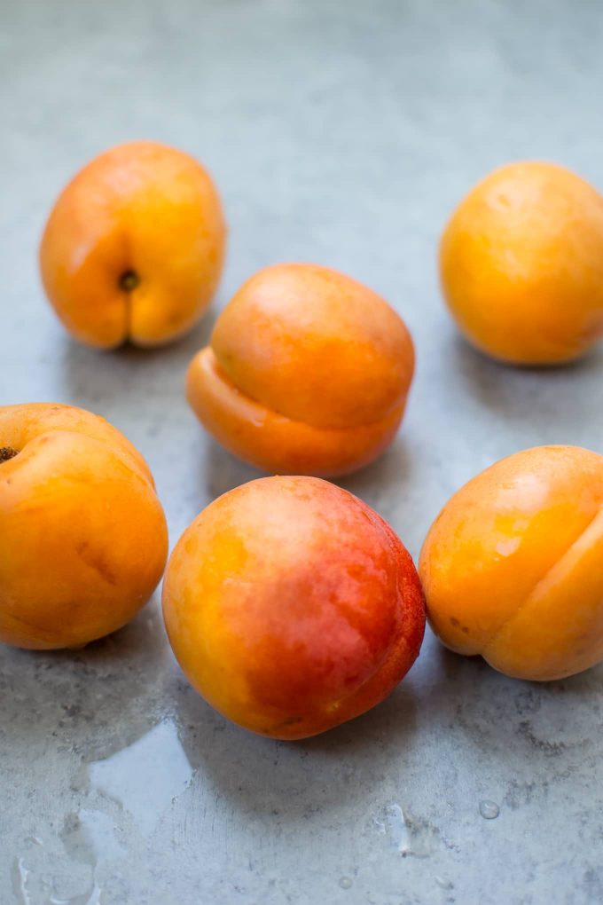 several whole apricots on a counter