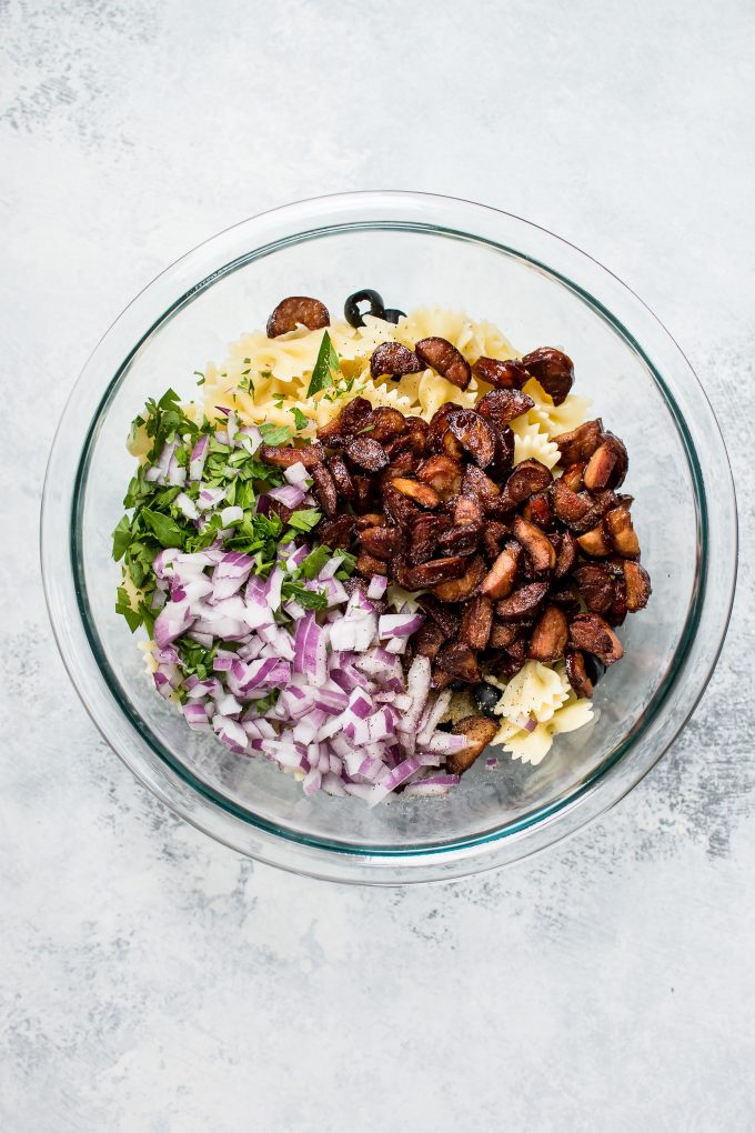 glass bowl with ingredients for spicy chorizo pasta salad