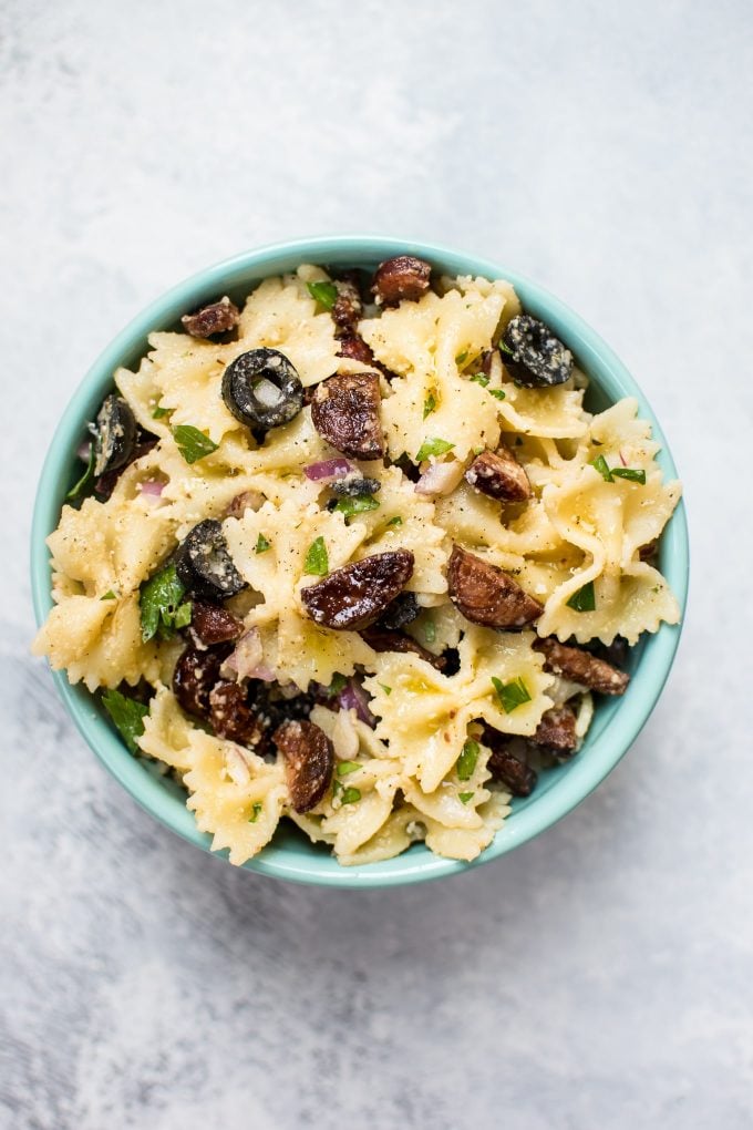 chorizo pasta salad with zesty vinaigrette in a teal bowl