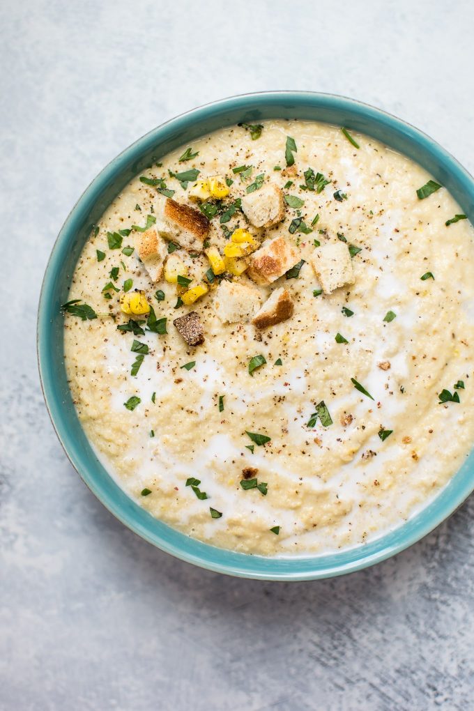 teal bowl with creamy corn and cauliflower soup