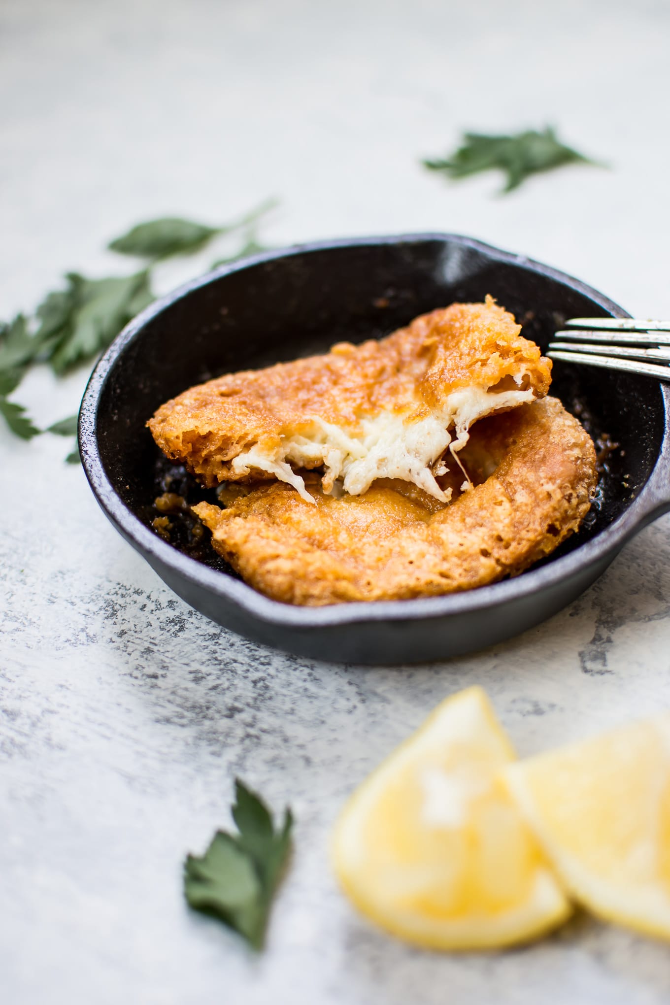 close-up of tiny cast iron skillet with saganaki Greek fried cheese