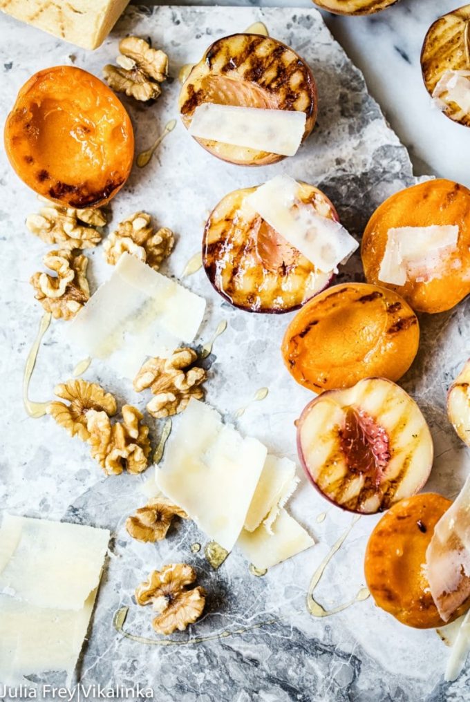 several grilled peaches with shaved cheese and walnuts