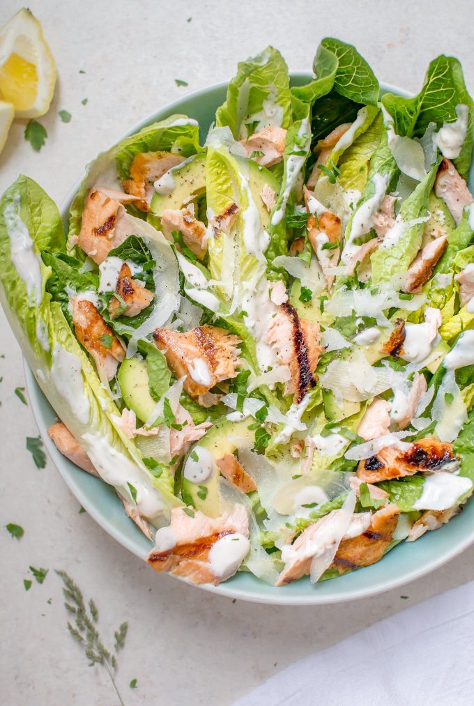 teal bowl with healthier grilled salmon Caesar salad