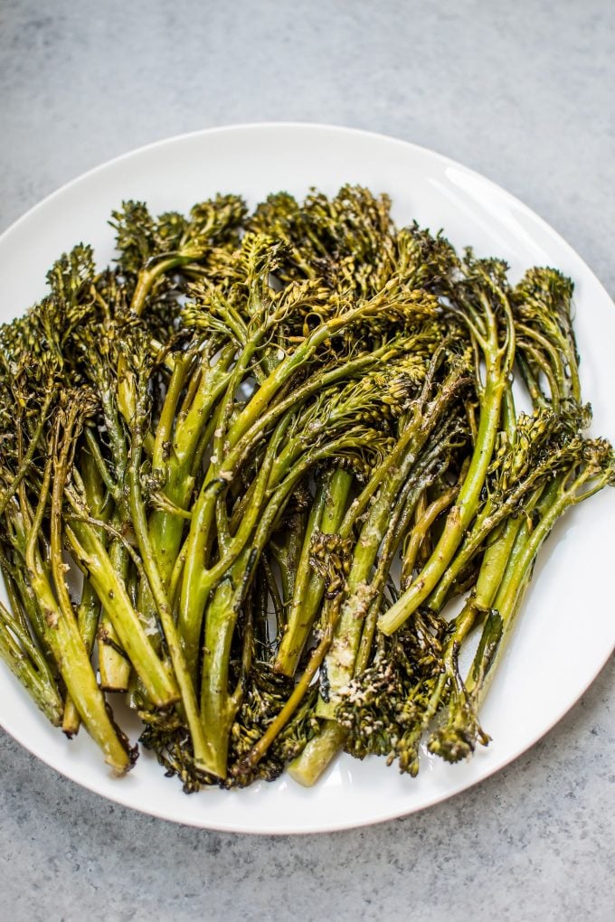 roasted balsamic parmesan broccolini on a white plate