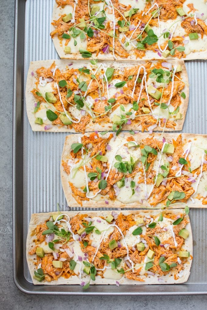 skinny buffalo chicken flatbread pizza on a baking sheet