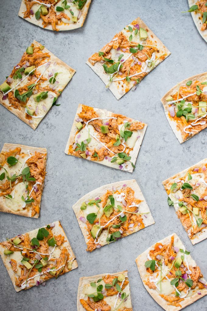 several pieces of skinny buffalo chicken flatbread pizza on a counter