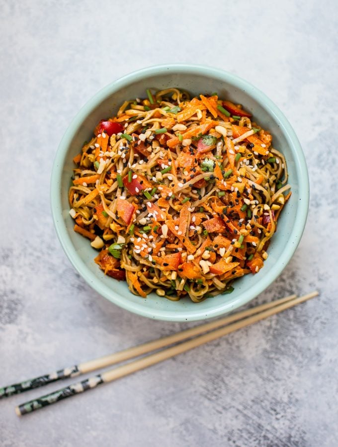 teal bowl with spicy peanut soba noodle salad beside chopsticks