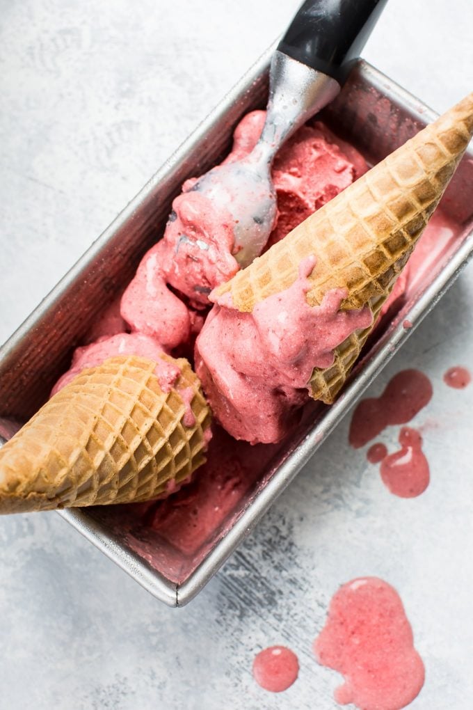 strawberry vegan ice cream with two cones and a scoop
