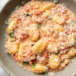 a bowl of creamy tomato gnocchi with grated parmesan