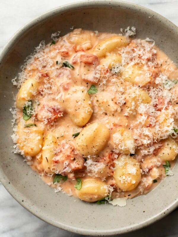a bowl of creamy tomato gnocchi with grated parmesan