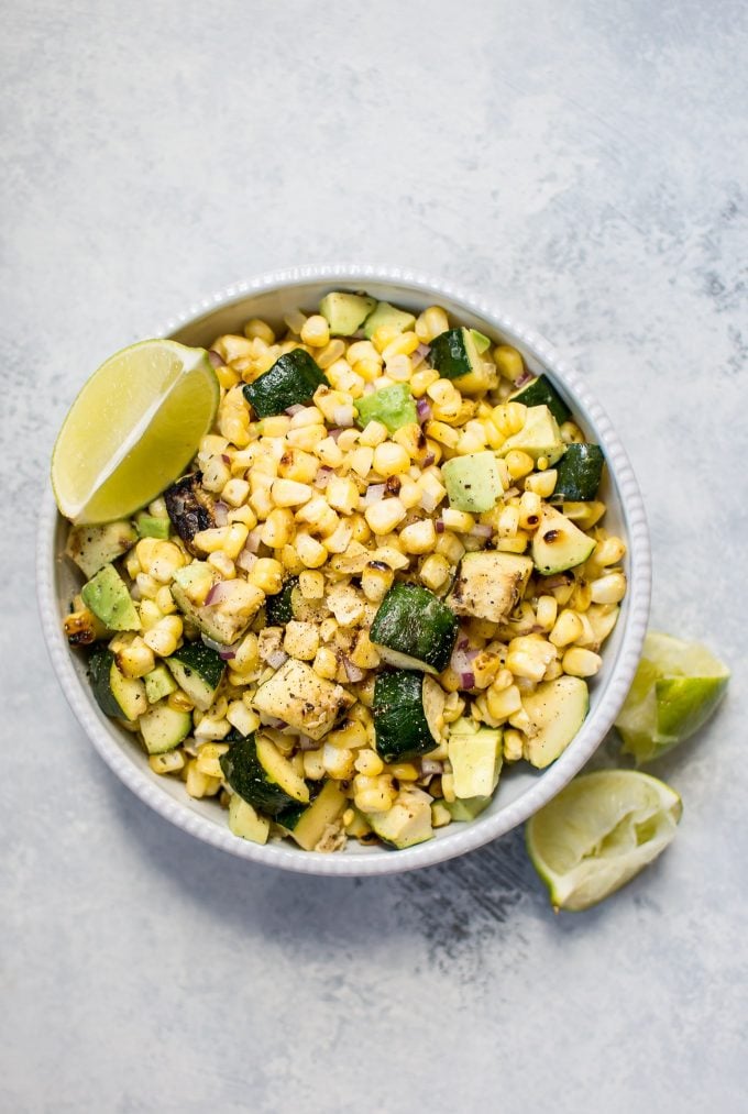 grilled corn and zucchini salad with avocado in a bowl