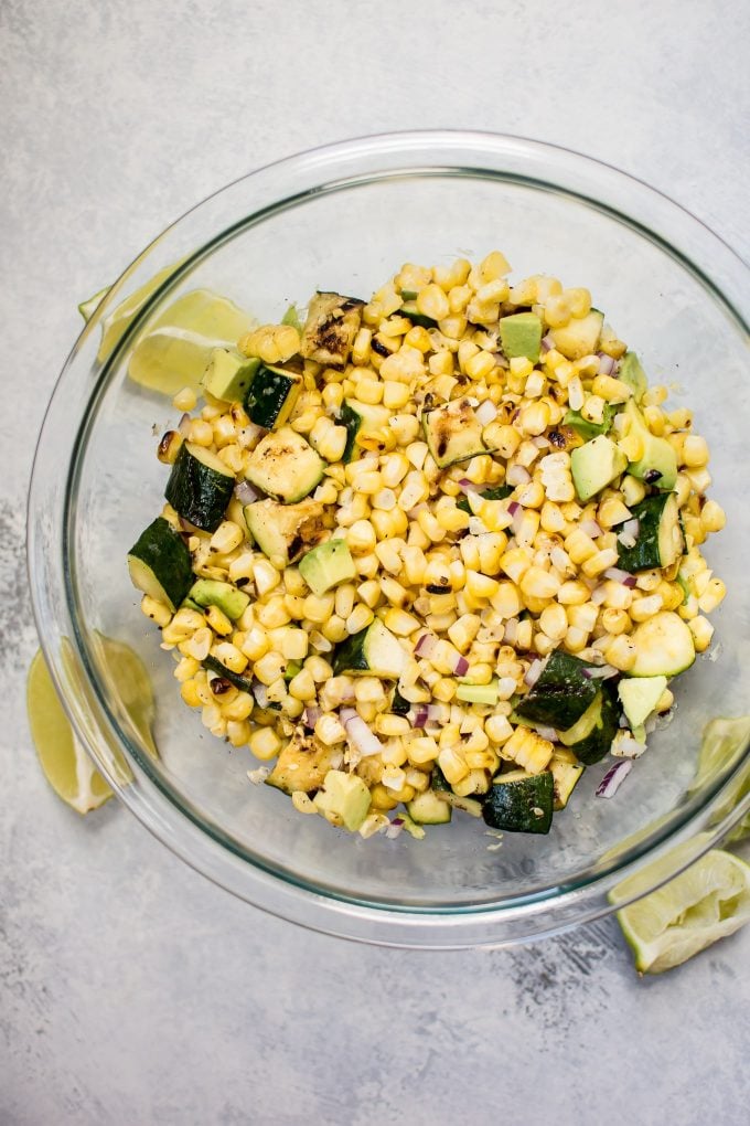 glass mixing bowl with grilled corn and zucchini salad