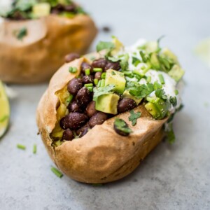 These healthy stuffed sweet potatoes make a fabulous light meal or side! Black beans with a quick lime dressing, Greek yogurt, avocado, and chives top these flavor-packed bundles of deliciousness.
