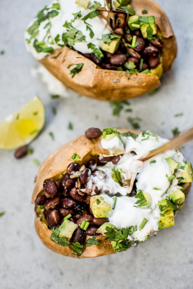 close-up of healthy stuffed sweet potato with avocado, Greek yogurt, and chives