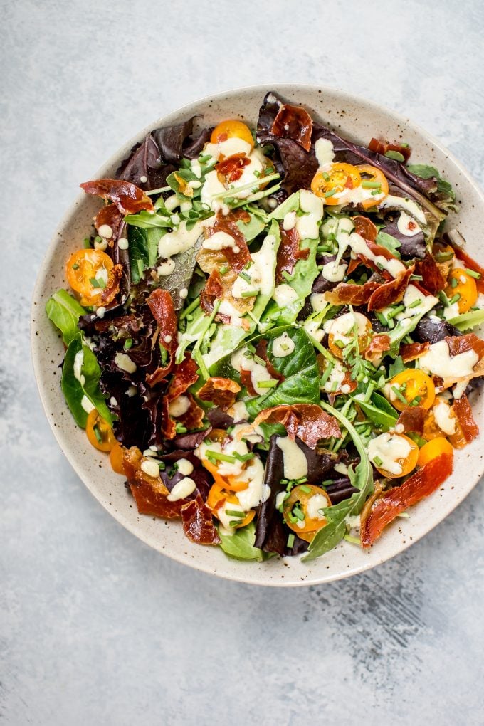 mixed greens prosciutto salad in a large bowl