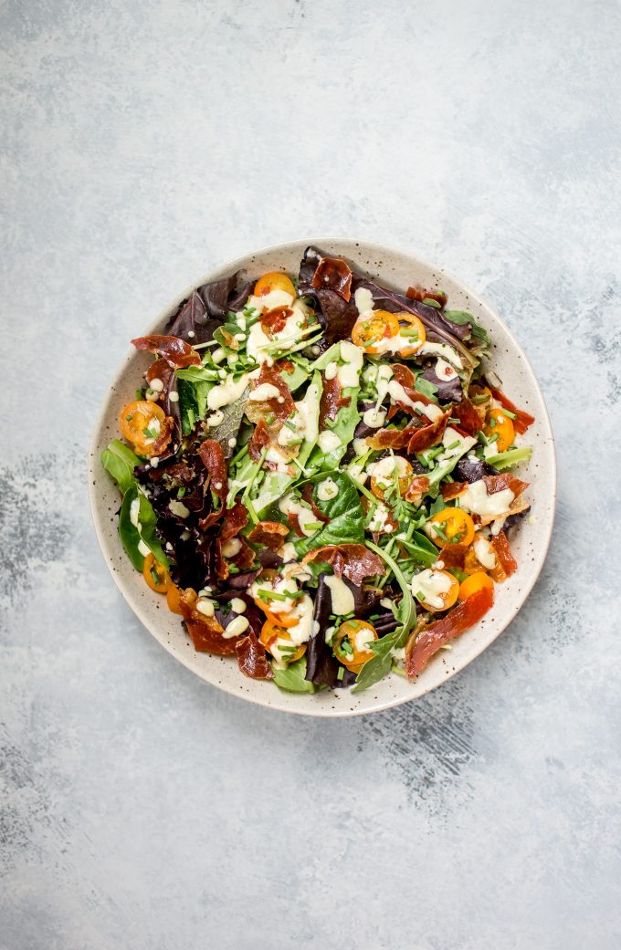 bowl of mixed greens salad with crispy Italian prosciutto