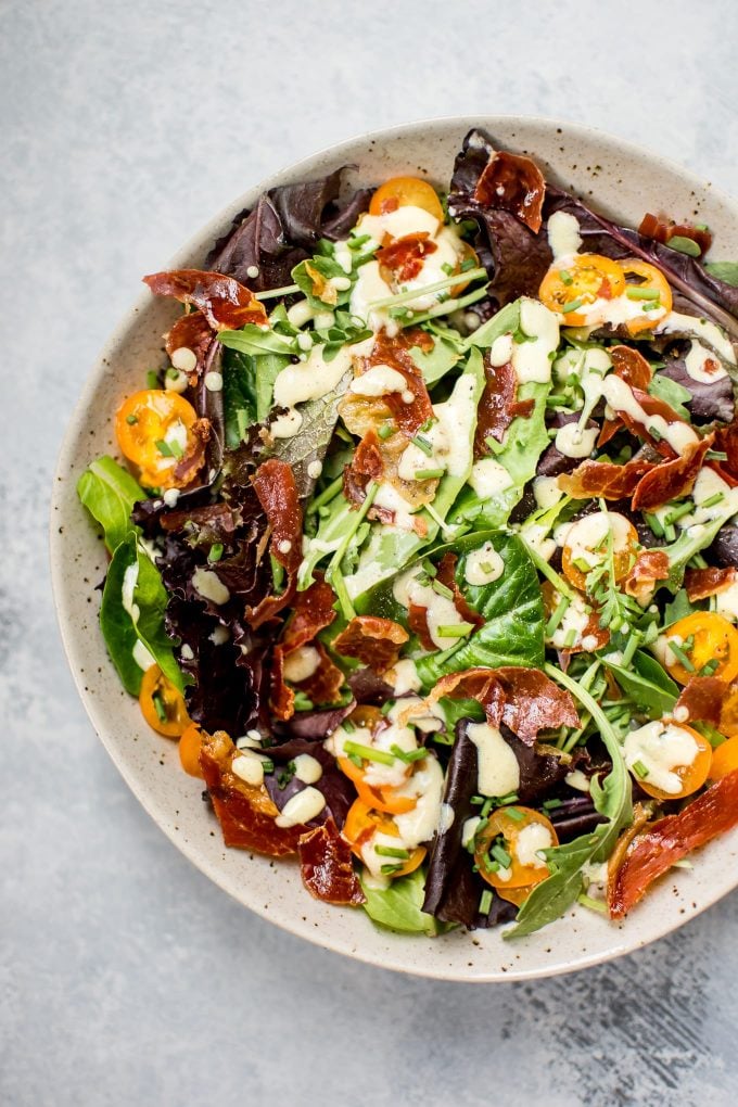 mixed greens salad with crispy prosciutto on a plate