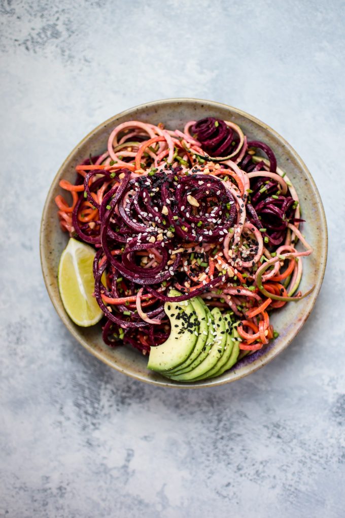 healthy vegetable noodle salad with avocado lime dressing in a bowl