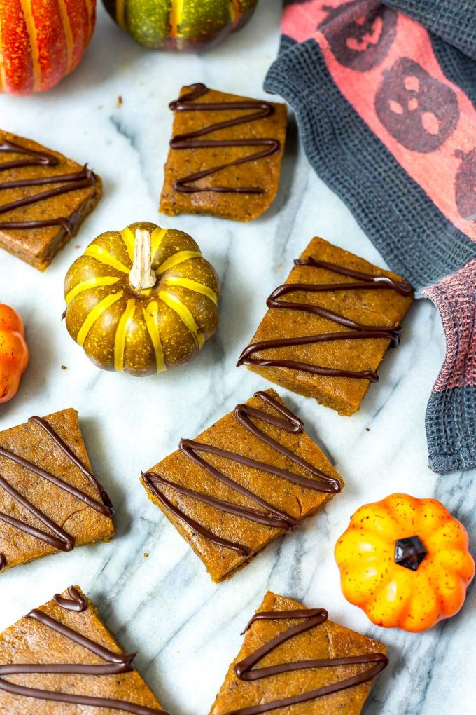 several pumpkin spice latte protein bars on a counter with mini pumpkins