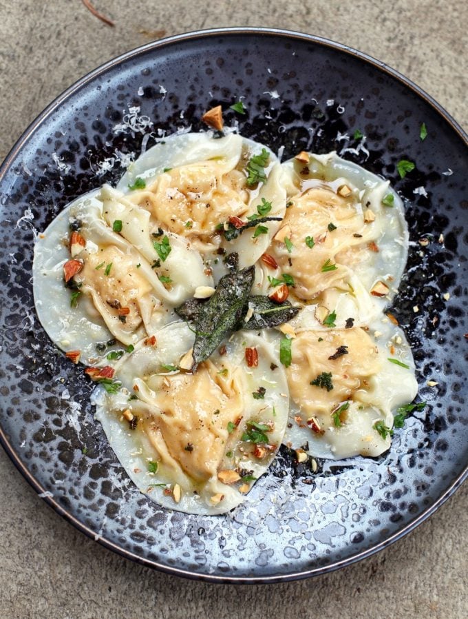 smoked pumpkin ravioli in a blue bowl