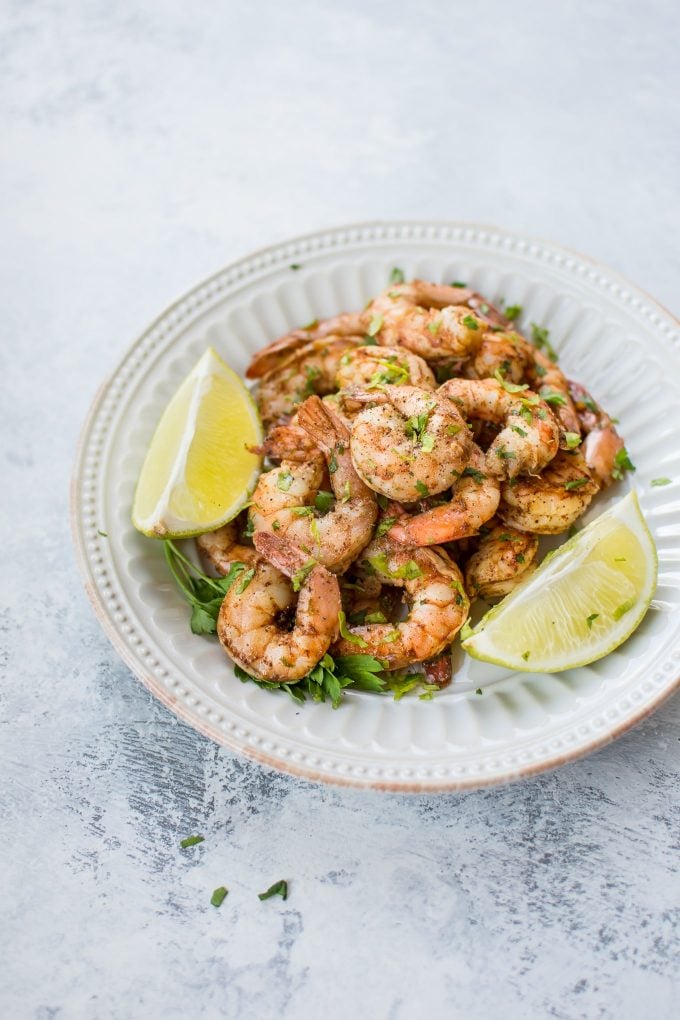 baked chili lime shrimp in a bowl with lime wedges