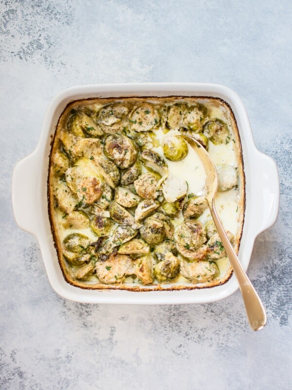 These creamy baked Brussels sprouts with garlic, parmesan, and a touch of brandy make an easy and decadent side dish that's tasty enough for a special occasion.