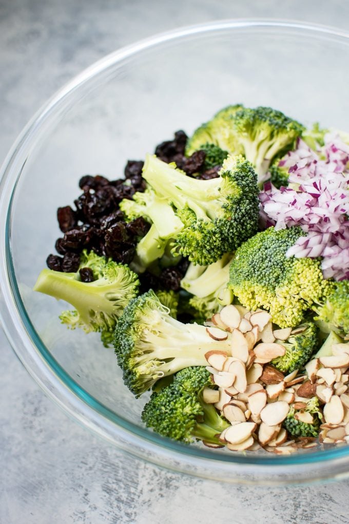 ingredients for healthy broccoli salad in a glass bowl