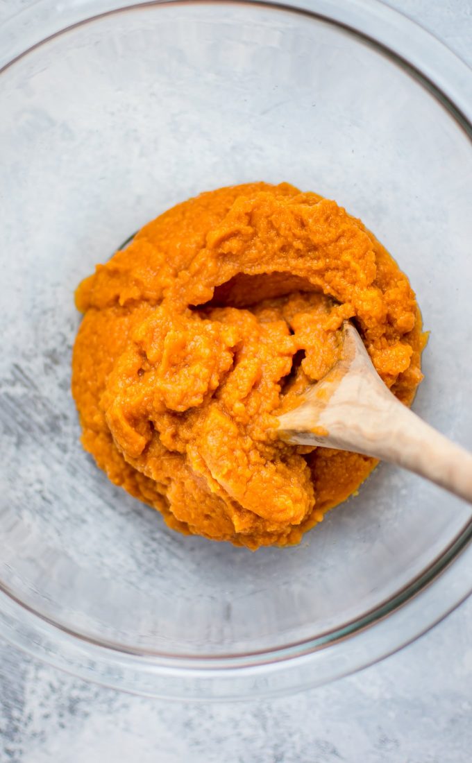 glass bowl with pumpkin puree and wooden spoon