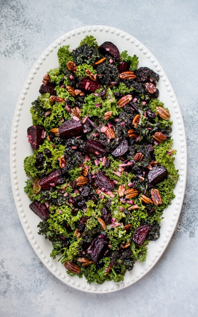 oval serving plate with roasted beet and kale salad with cranberries and pecans
