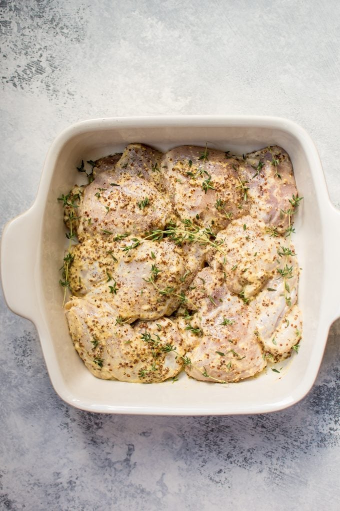 mustard chicken thighs in a baking dish ready for the oven