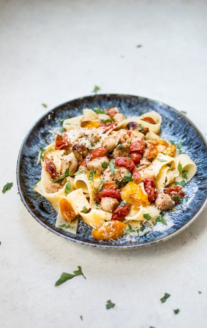 healthy chicken sausage pasta with roasted tomatoes on a blue plate