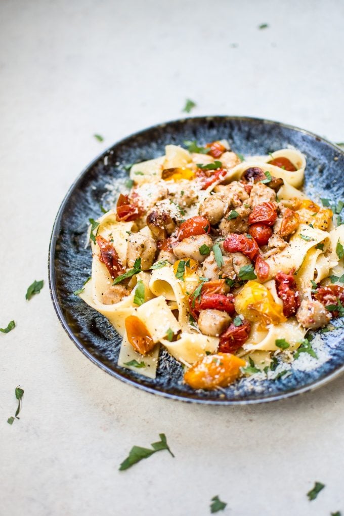 healthy chicken sausage pasta with roasted tomatoes on a blue plate