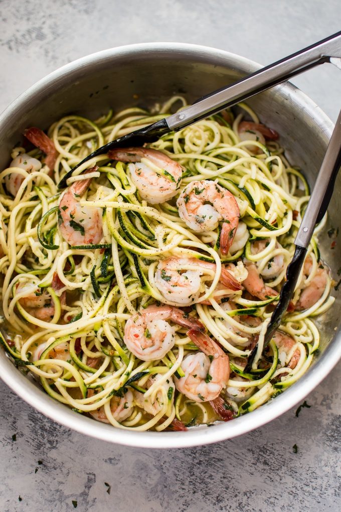 metal skillet with sweet chili shrimp zucchini noodles and tongs